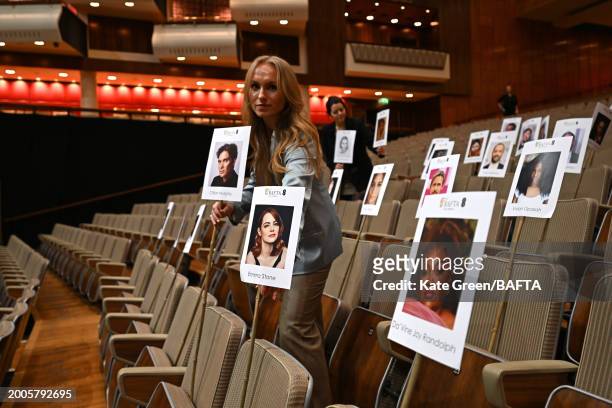 Staff members lay out heads on sticks marking the EE BAFTA Film Awards 2024 seating plan during the "Heads On Sticks" photocall ahead of the EE BAFTA...