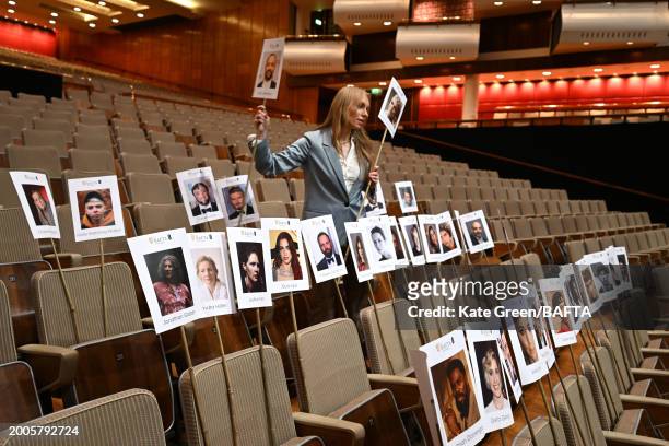 Staff member lays out heads on sticks marking the EE BAFTA Film Awards 2024 seating plan during the "Heads On Sticks" photocall ahead of the EE BAFTA...