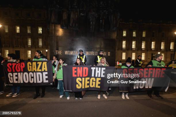 Protestors hold banners at Downing Street on February 12, 2024 in London, England. Stop The War Coalition and other pro-Palestinian groups are...