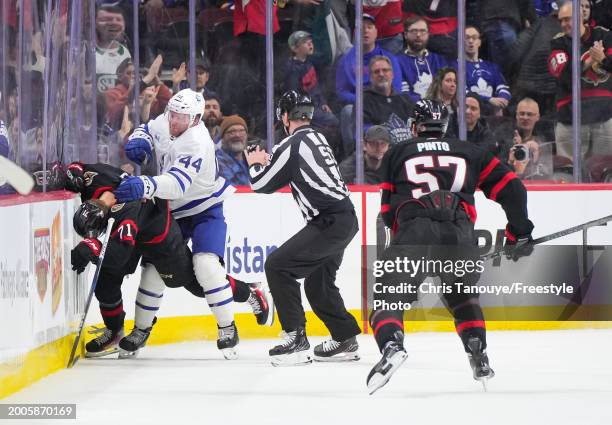 Morgan Rielly of the Toronto Maple Leafs stands over Ridly Greig of the Ottawa Senators after being cross checked in the head following his empty net...