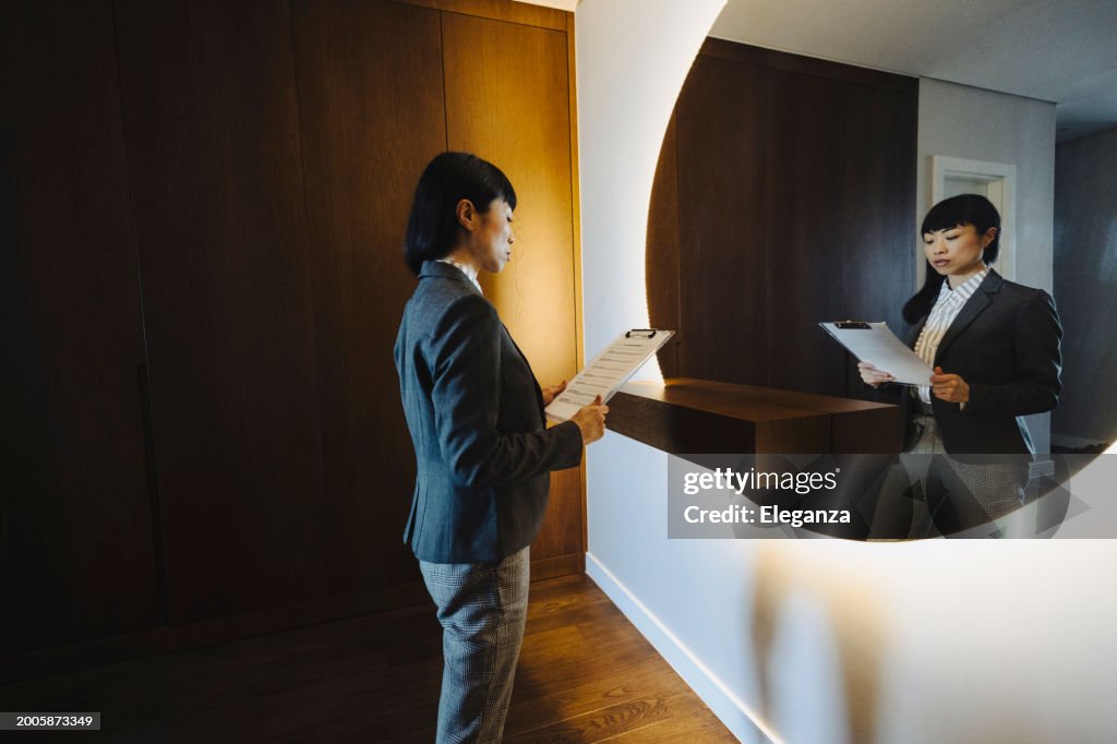 One woman, rehearsing a speech in mirror at home.