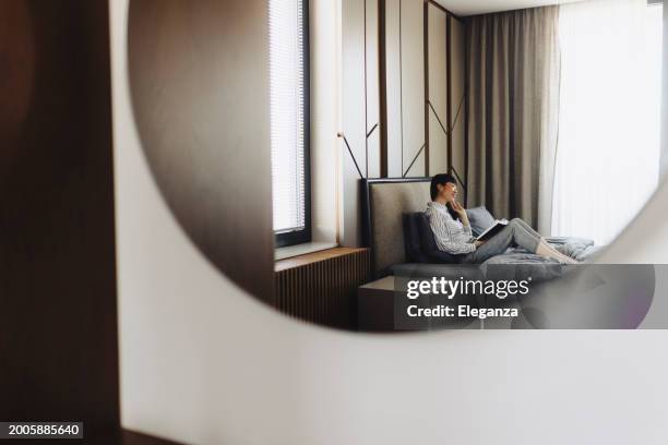 donna d'affari che legge il libro e riposa nella stanza d'albergo - albergo di lusso foto e immagini stock