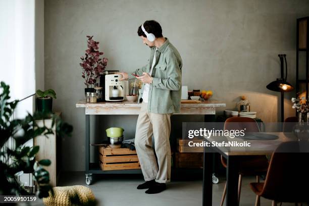 young casually clothed man making coffee - coffee maker stock pictures, royalty-free photos & images