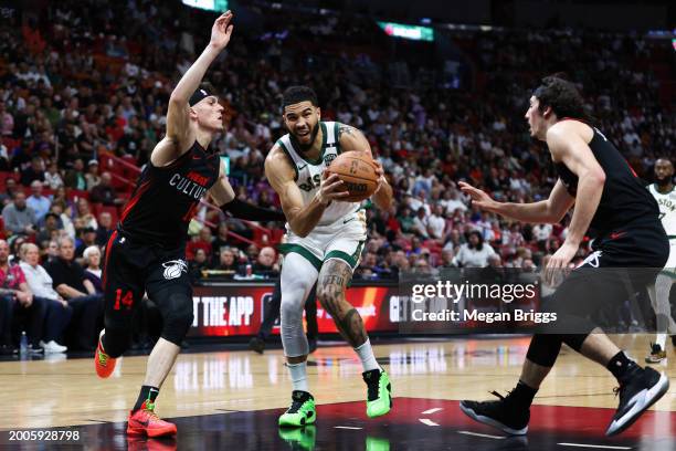 Jayson Tatum of the Boston Celtics drives to the basket against Tyler Herro and Jaime Jaquez Jr. #11 of the Miami Heat during the first quarter of...