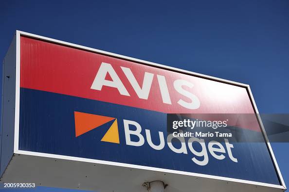 Avis Rental Sign A sign marks the location of an Avis and Budget car rental facility ...