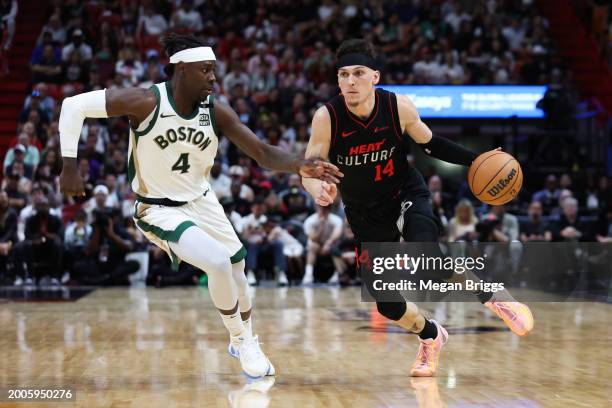 Tyler Herro of the Miami Heat dribbles the ball against Jrue Holiday of the Boston Celtics during the fourth quarter of the game at Kaseya Center on...