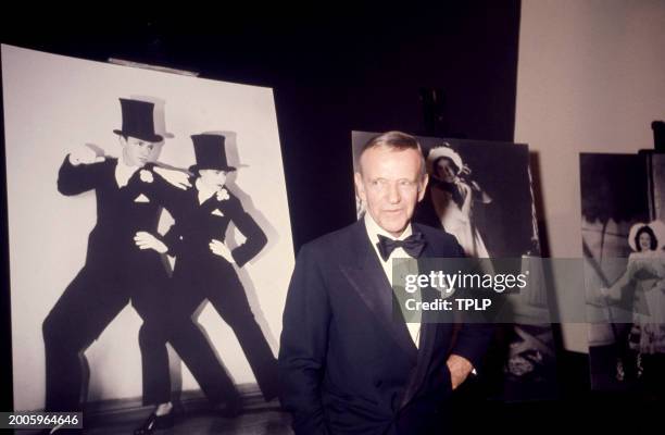 American actor and dancer Fred Astaire poses for a portrait in front of a picture of himself and his sister Adele Astaire in New York, New York,...