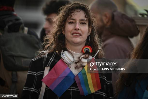 Person gathers with fellow LGBTQ community members outside the Greek Parliament as lawmakers vote on a same-sex marriage and adoption for same-sex...