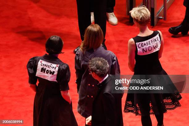 Danish film producer and GWFF Best First Feature Award Jury member Katrin Pors poses with banner on her back reading 'Ceasefire now' next to other...