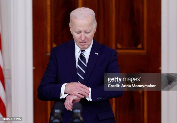 President Joe Biden checks his watch as he arrives to deliver remarks to welcome King of Jordan Abdullah II ibn Al Hussein to the White House on...