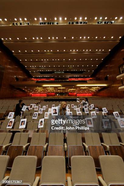 Staff member lays out heads on sticks marking the seating plan during the "Heads On Sticks" photocall ahead of the EE BAFTA Film Awards 2024 at The...