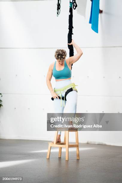 junge frau rückt bungee-seil auf eine leiter. - bungee cord stock-fotos und bilder