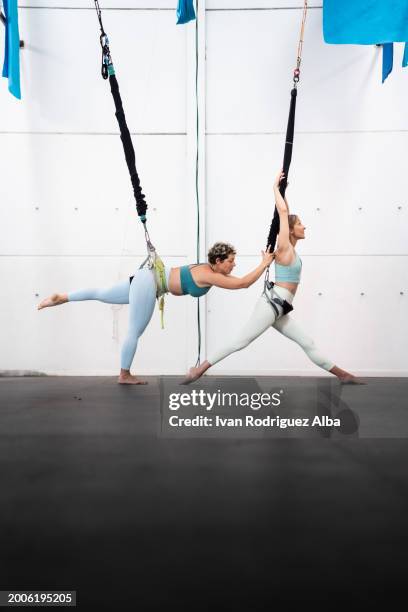 adult women practice bungee workout in gym - bungee cord stock pictures, royalty-free photos & images
