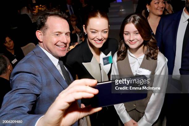 Emma Stone takes a selfie with guests during the 96th Oscars Nominees Luncheon at The Beverly Hilton on February 12, 2024 in Beverly Hills,...