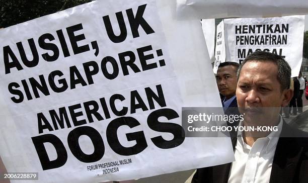 An Indonesian Muslim holds a placard during a protest along a street in Jakarta, 19 August 2003. The protesters are against US, UK and Australian...