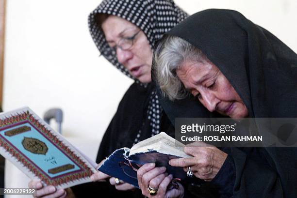 Two Iranian women pray as they listen to a Muslim preacher reciting the Koran in Singapore, 09 July 2003. Iranians gathered for a private farewell to...
