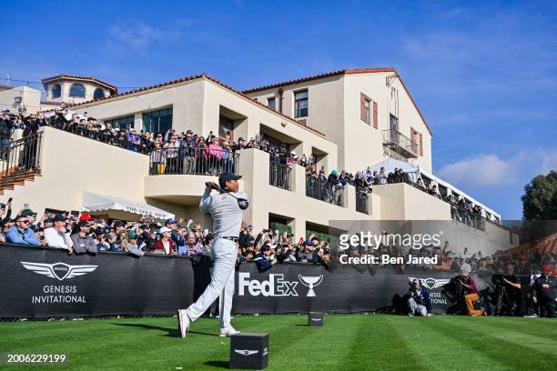 Tiger Woods plays his shot from the first hole tee as fans watch during the first round of The Genesis Invitational at Riviera Country Club on...
