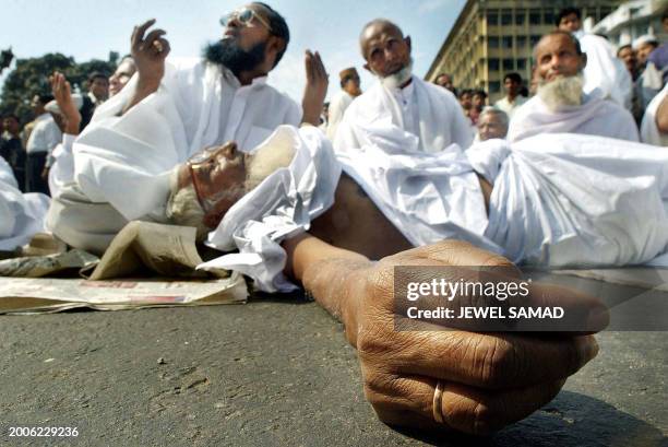 Samsul Haq, a 72 years-old muslim pilgrim, lies on the ground while others pray during a demonstration in Dhaka, 04 February 2003. 48 pilgrims...