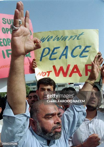 An activist from Pakistan's Shiite Muslim minority raises his arms as he chants anti-war slogans during a protest in Islamabad, 11 April 2003....