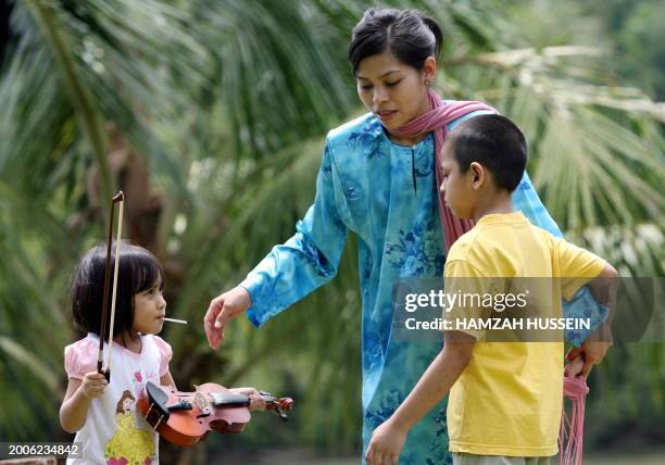 Malaysia-Islam-religion-crime-Singapore BY M. JEGATHESAN Muslim model Kartika Sari Dewi Shukarno plays with her son Muhammad Azfar and daughter Wann...