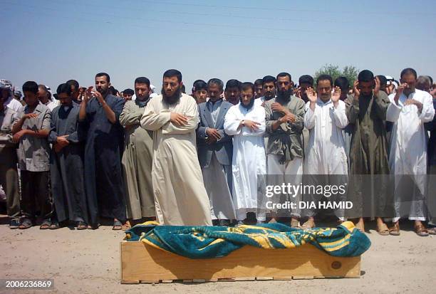 Iraqis pray over the body of an Iraqi who was killed in a car bomb explosion 06 May 2005 in the northern city of Tikrit. Twelve Iraqis, including...