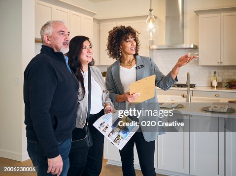 Agente de bienes raíces que muestra una nueva casa a posibles compradores Agente de bienes raíces que muestra una nueva casa a posibles compradores