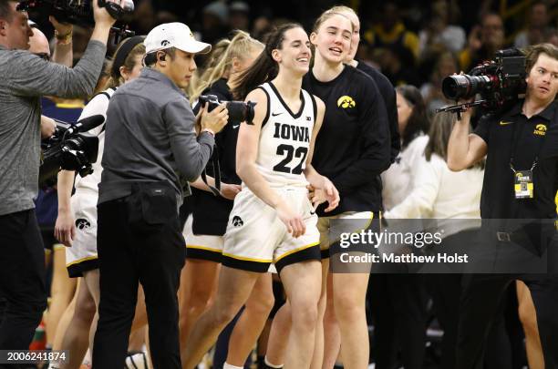 Guard Caitlin Clark of the Iowa Hawkeyes is surrounded by teammates after breaking the NCAA women's all-time scoring record, surpassing the previous...
