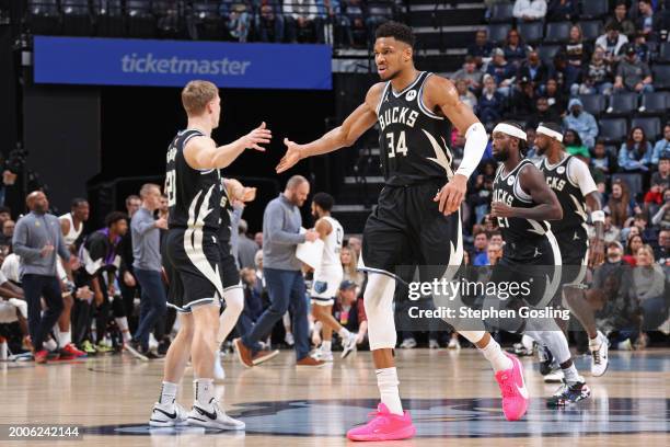 Giannis Antetokounmpo of the Milwaukee Bucks high fives AJ Green during the game against the Memphis Grizzlies on February 15, 2024 at FedExForum in...