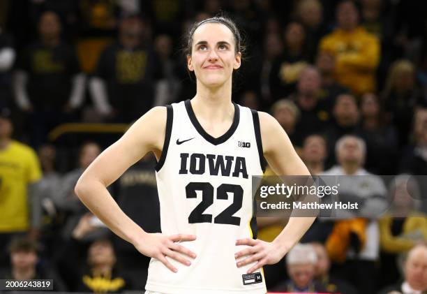 Guard Caitlin Clark of the Iowa Hawkeyes listens as the crowd cheers after breaking the NCAA women's all-time scoring record during the game against...