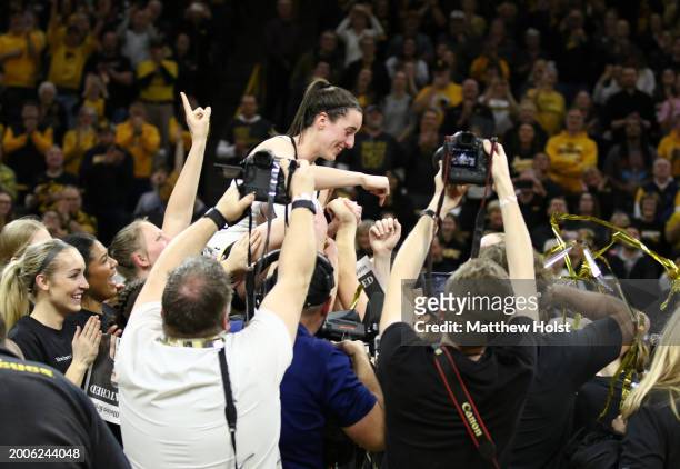 Guard Caitlin Clark of the Iowa Hawkeyes is hoisted by teammates during a presentation after breaking the NCAA women's all-time scoring record during...