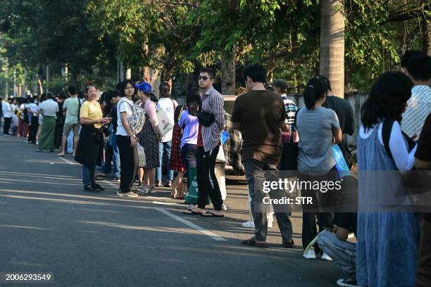 People stand in line to get visas at the embassy of Thailand in Yangon on February 16 after Myanmar's military government said it would impose...