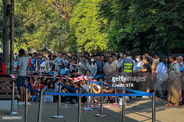 People gather outside the embassy of Thailand to get visas in Yangon on February 16 after Myanmar's military government said it would impose military...