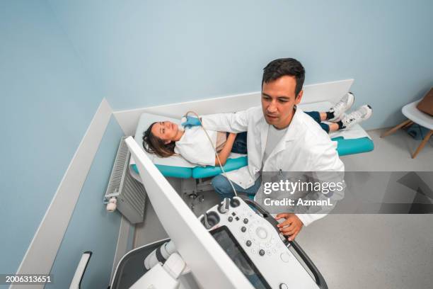 expert sonographer conducts thyroid ultrasound - hyperthyroidism stock pictures, royalty-free photos & images