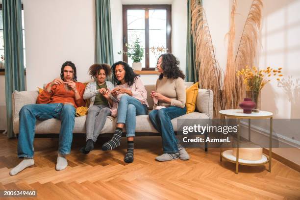 cheerful mixe raced family knitting in the living room - raced stock pictures, royalty-free photos & images