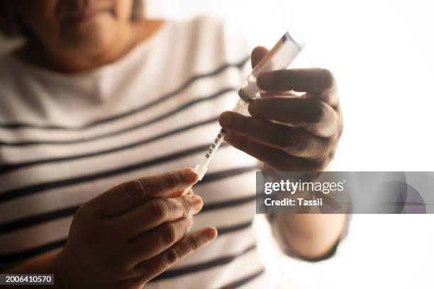 diabetes, inyección y mano con vial para insulina, medicamento y vacuna o inyección de atención médica. medicamentos, cuidados y persona con jeringa y líquido para medicación, protección contra virus y seguridad - insulina fotografías e imágenes de stock