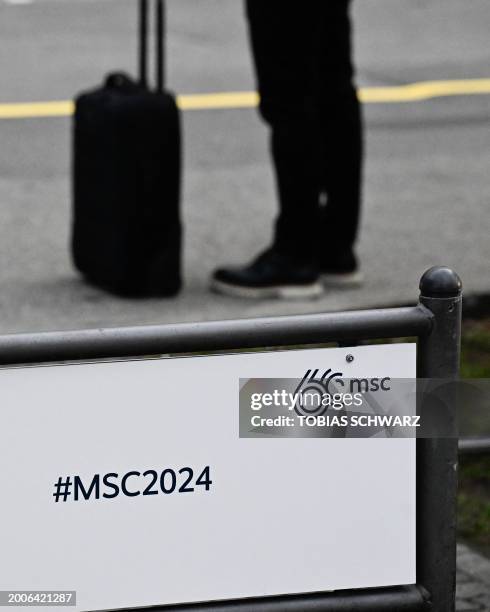 Person with a suitcase stands in front of the Bayerischer Hof hotel, the venue for the 60th Munich Security Conference in Munich, southern Germany,...