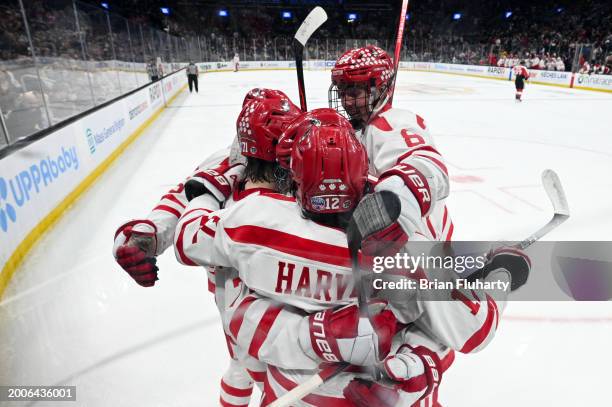 Macklin Celebrini of Boston University celebrates with Cade Webber and Jack Harvey after scoring a goal against Northeastern during the first period...