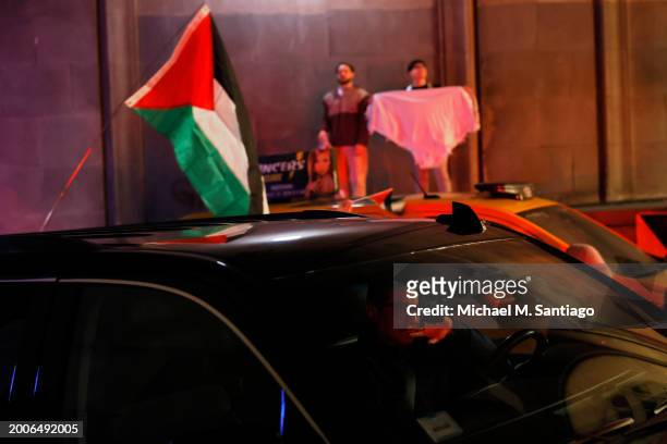 Person sits in their car as people march calling on Israel to stop its Rafah invasion in Gaza on February 12, 2024 in New York City. Israel launched...
