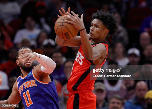 Amen Thompson of the Houston Rockets grabs a rebound ahead of Jalen Brunson of the New York Knicks during the first half at Toyota Center on February...