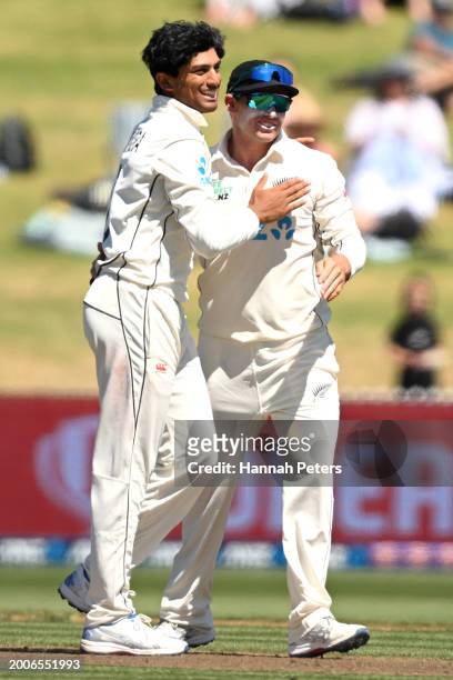 Rachin Ravindra of the New Zealand Black Caps celebrates the wicket of Keegan Petersen of South Africa with Tom Latham during day one of the Men's...