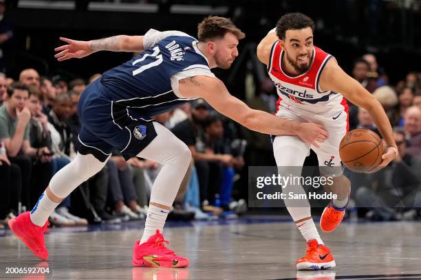 Tyus Jones of the Washington Wizards drives by Luka Doncic of the Dallas Mavericks during the first half at American Airlines Center on February 12,...