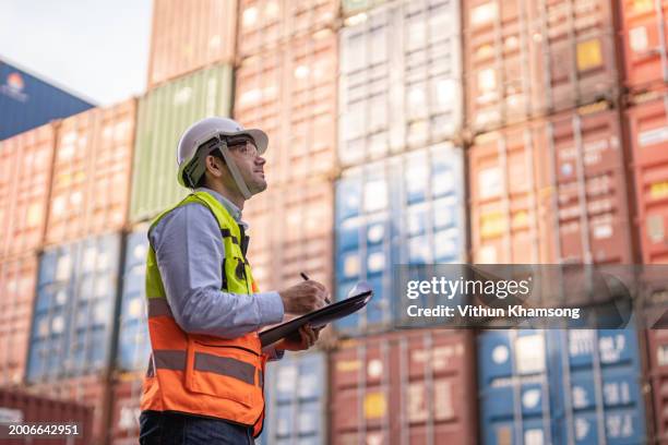 male engineer examining checklist work at containers yard. cargo port storage for transportation and trading. - inspector fotografías e imágenes de stock