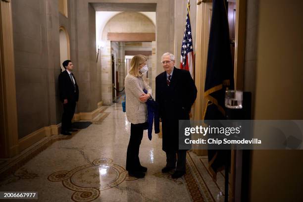 Senate Minority Leader Mitch McConnell talks with Sen. Lisa Murkowski as he leaves his office following a series of votes at the U.S. Capitol on...