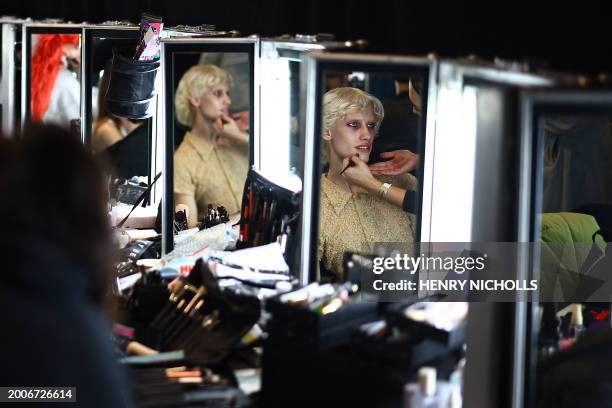 Model gets makeup done backstage ahead of a catwalk presentation for London-based Ukrainian designer Masha Popova's Autumn/Winter 2024 collection,...