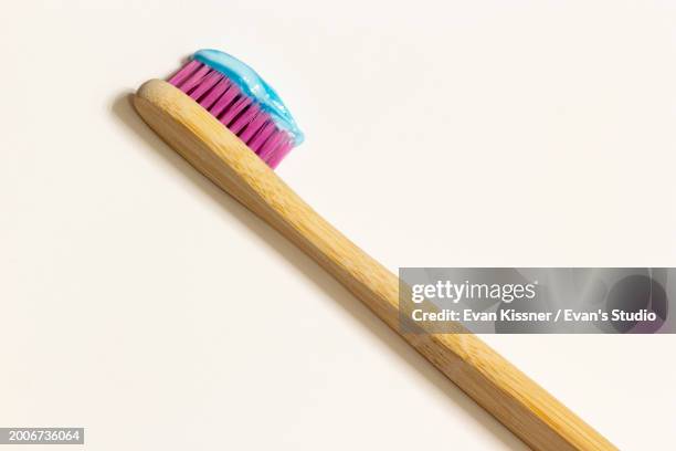 wooden toothbrush with pink bristles on white background - fluor stockfoto's en -beelden