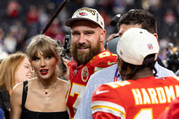 Travis Kelce of the Kansas City Chiefs and Taylor Swift react as they see Mecole Hardman Jr. #12 of the Kansas City Chiefs following the NFL Super...