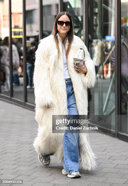 Charlotte Groeneveld is seen wearing a white Frankie Shop faux fur coat, white top, blue jeans, white bag and black sunglasses outside the Caroline...