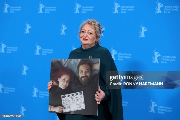 Iranian actress Lily Farhadpour holds a photograph depicting Iranian actress and screenwriter Maryam Moghaddam and Iranian film director and...