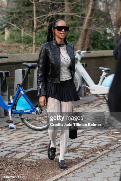Guest is seen wearing a black jacket, white top, black skirt, white tights and black shoes outside the Coach show during February 2024 New York...