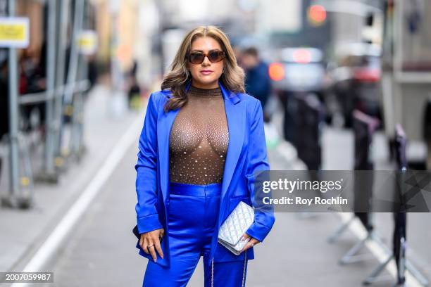 Brittney Brown wears an alice + olivia suit, a Lamarque shirt and a Chanel bag outside the Pamella Roland Show at Starrett-Lehigh Building during New...